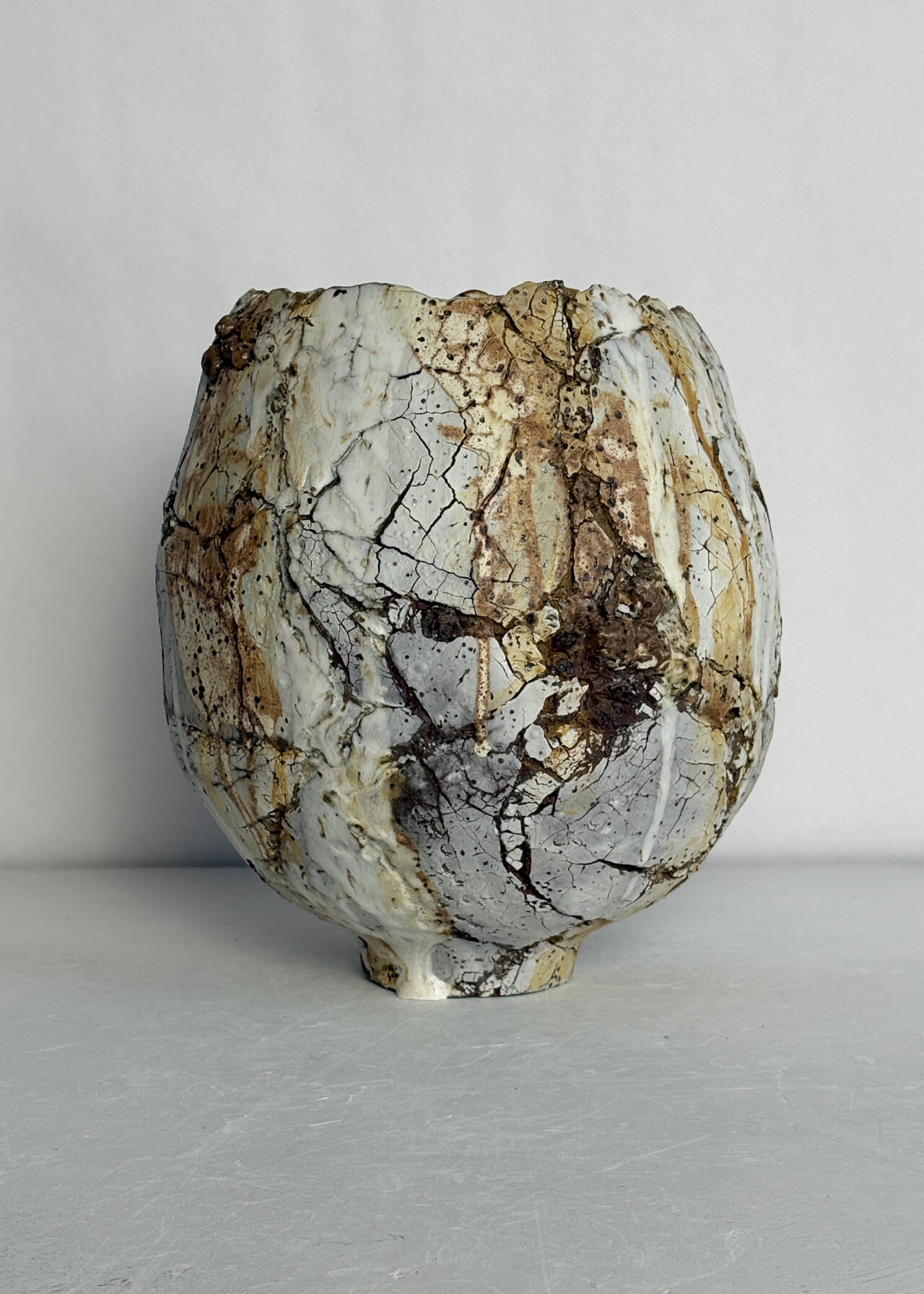 Handbuilt ceramic vessel with cracked, textured surface in earth tones, from the Scorched Earth series
