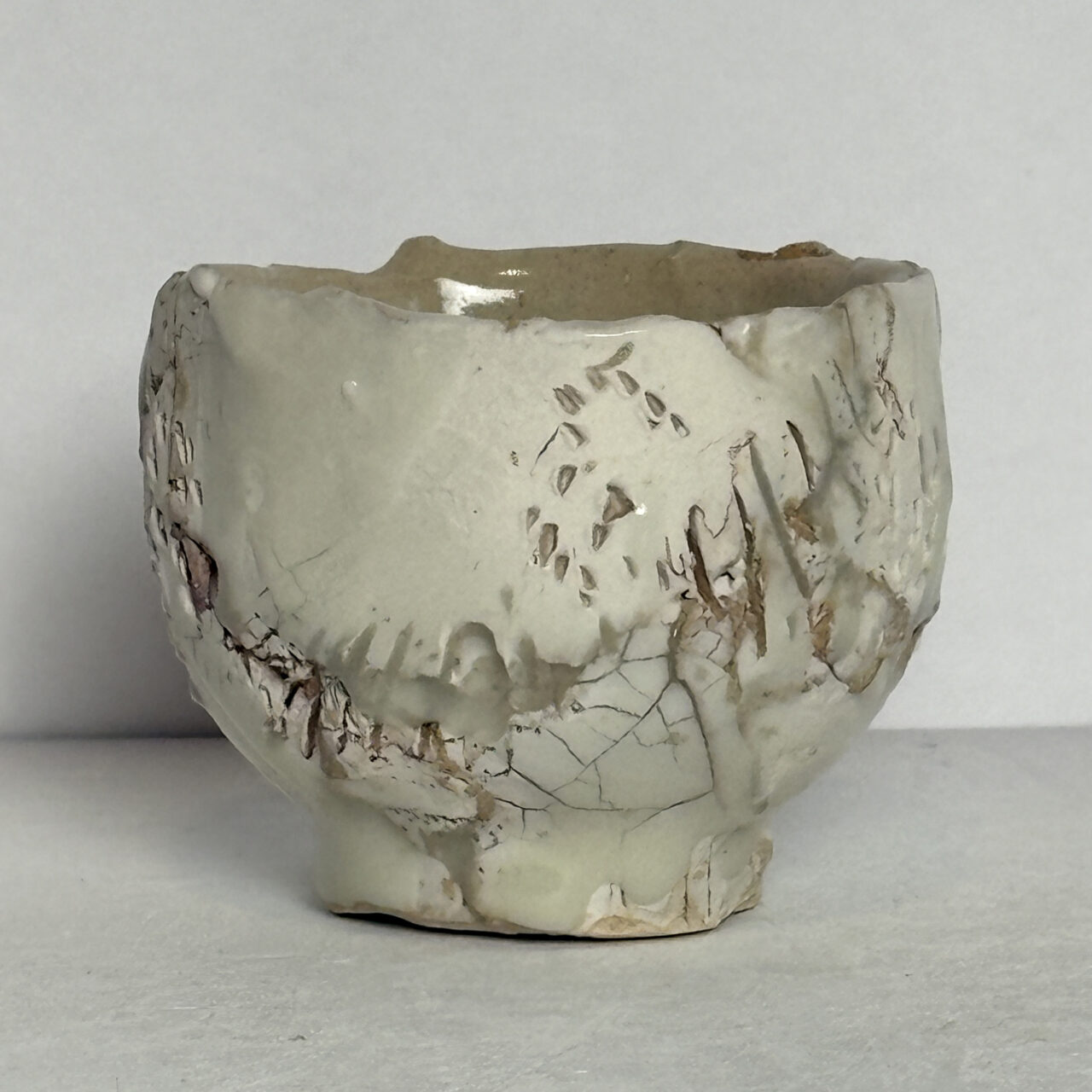 no. 84 Small ceramic vessel with white glaze, crackled surface, and warm brown streaks with subtle textural variation
