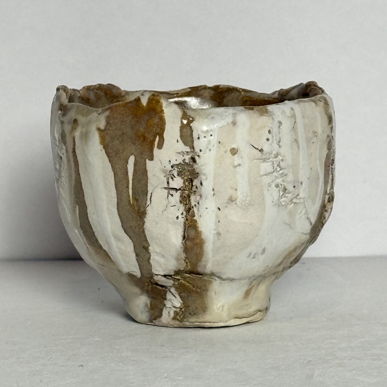 no. 87 Small ceramic vessel with white glaze, crackled surface, and vertical brown drips with subtle texture.