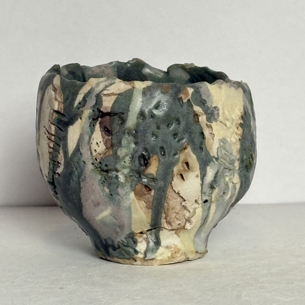 no. 89 Small ceramic vessel with layered glaze, crackled surface, and flowing green-gray drips over cream and brown areas.