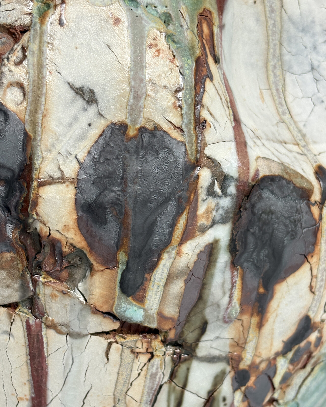 Texture detail of Vessel No. 35 showing layered black glaze pools, vertical glaze drips, crackled white surface, and warm rust-toned edges.