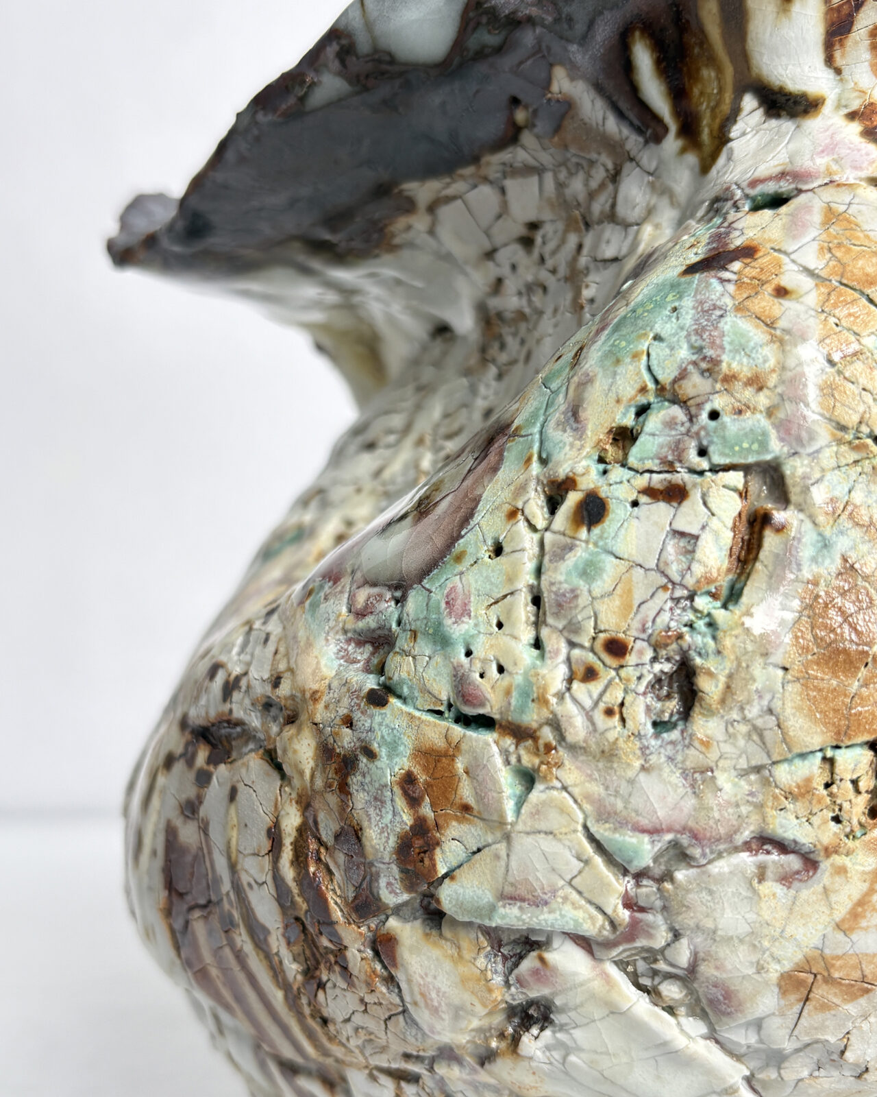 Detail view of Vessel No. 43 showing crackled white glaze, layered green and rust tones, and textured surface with sculptural folds and glaze variation.