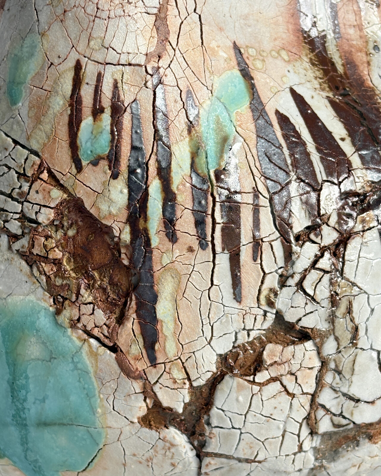 Texture detail of Vessel No. 57 showing crackled white glaze, turquoise glaze pools, dark brown linear markings, and rough rust-toned surface texture.