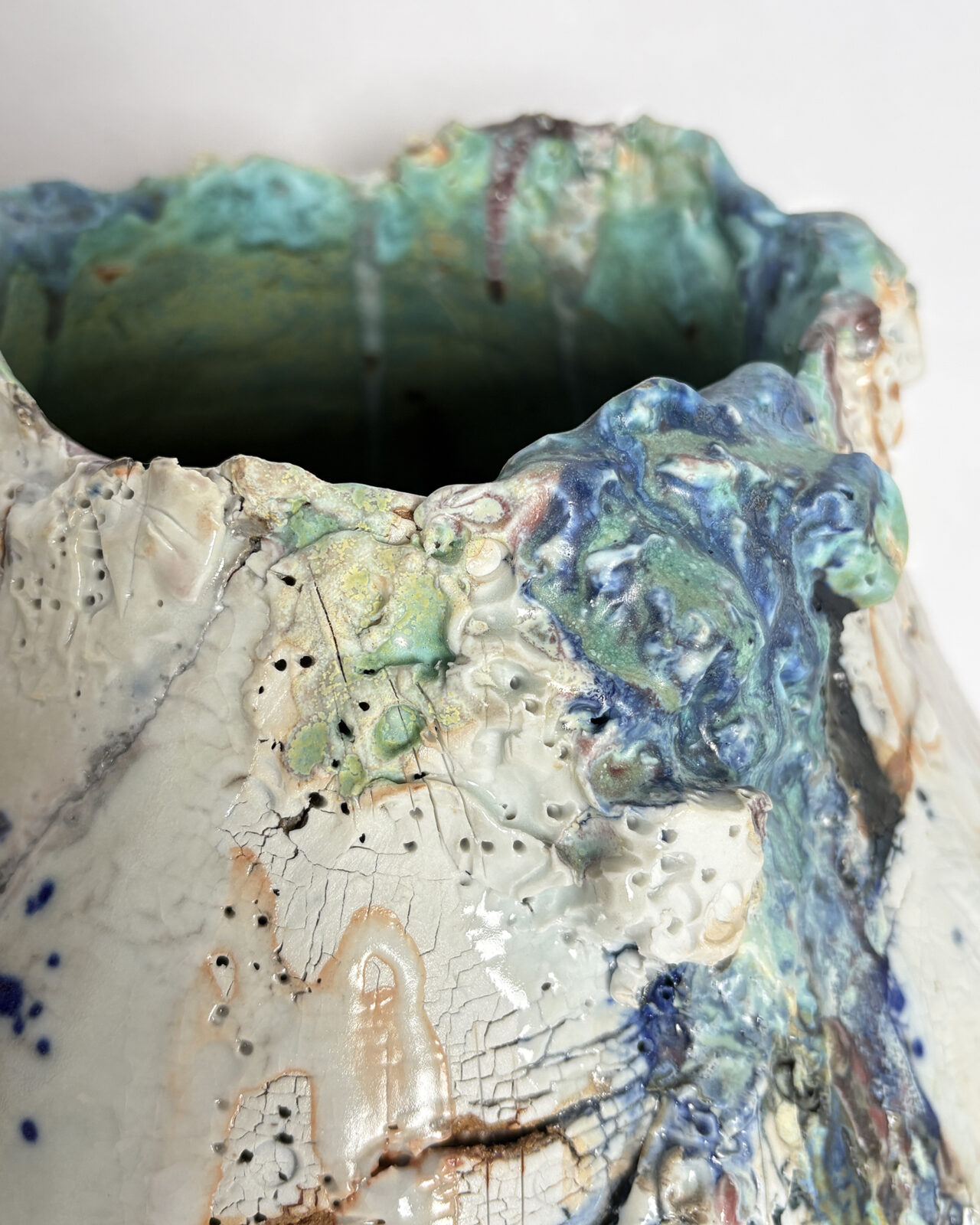 Vessel no. 66 - close up to show the rim and interior. Glaze colors of off white, blue and turquoise with rust red areas in the cracked surface
