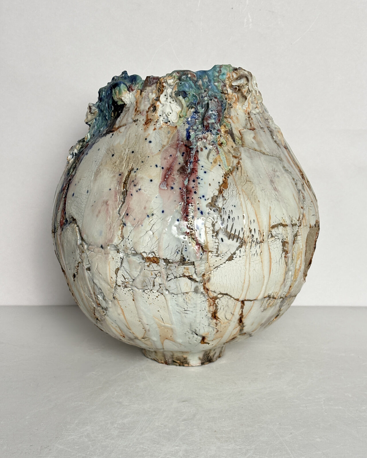 Vessel no. 66 - shows the vessel with glaze colors of off white, blue and turquoise with rust red areas in the cracked surface