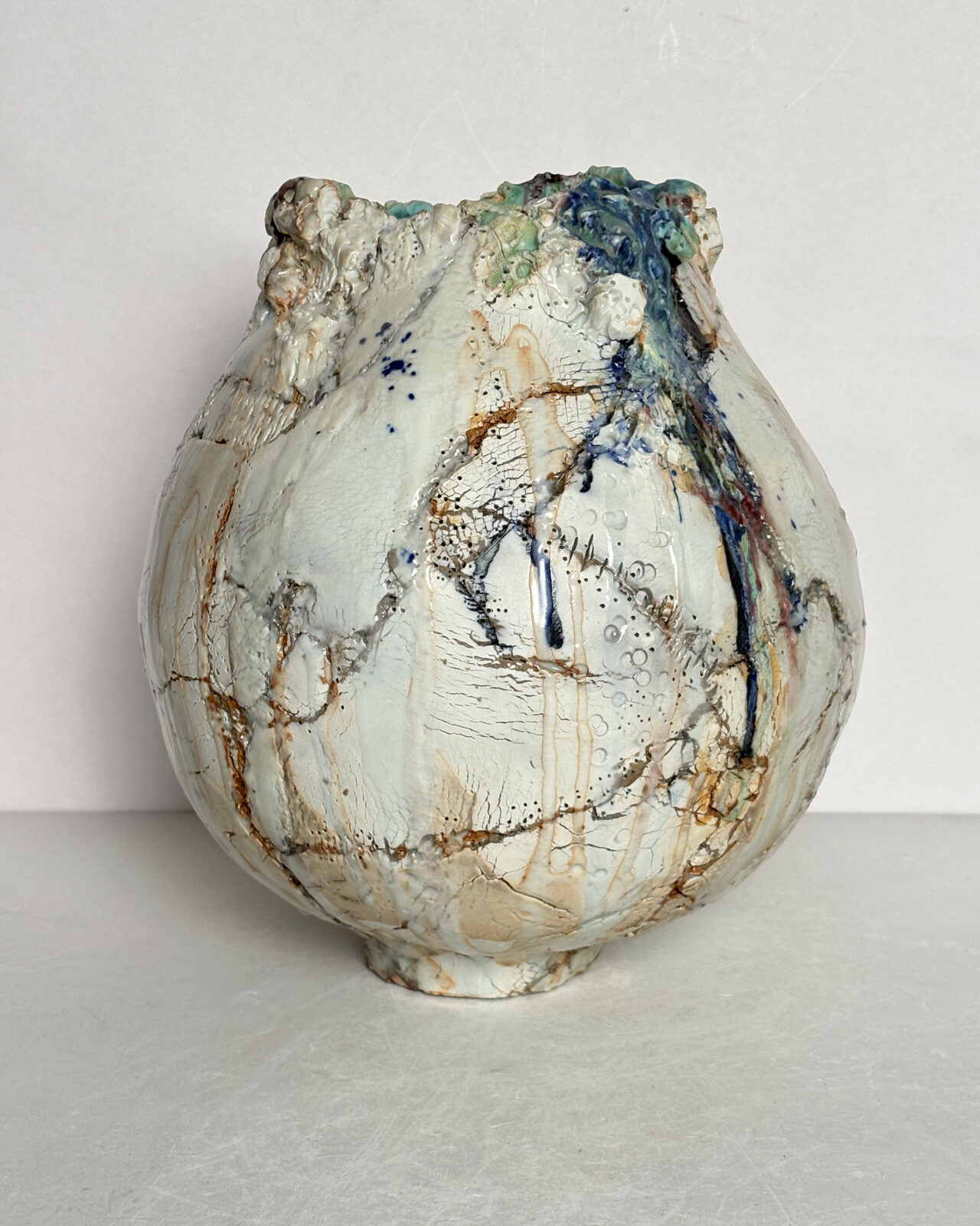 Vessel no. 66 - Side 3 shows the vessel with glaze colors of off white, blue and turquoise with rust red areas in the cracked surface