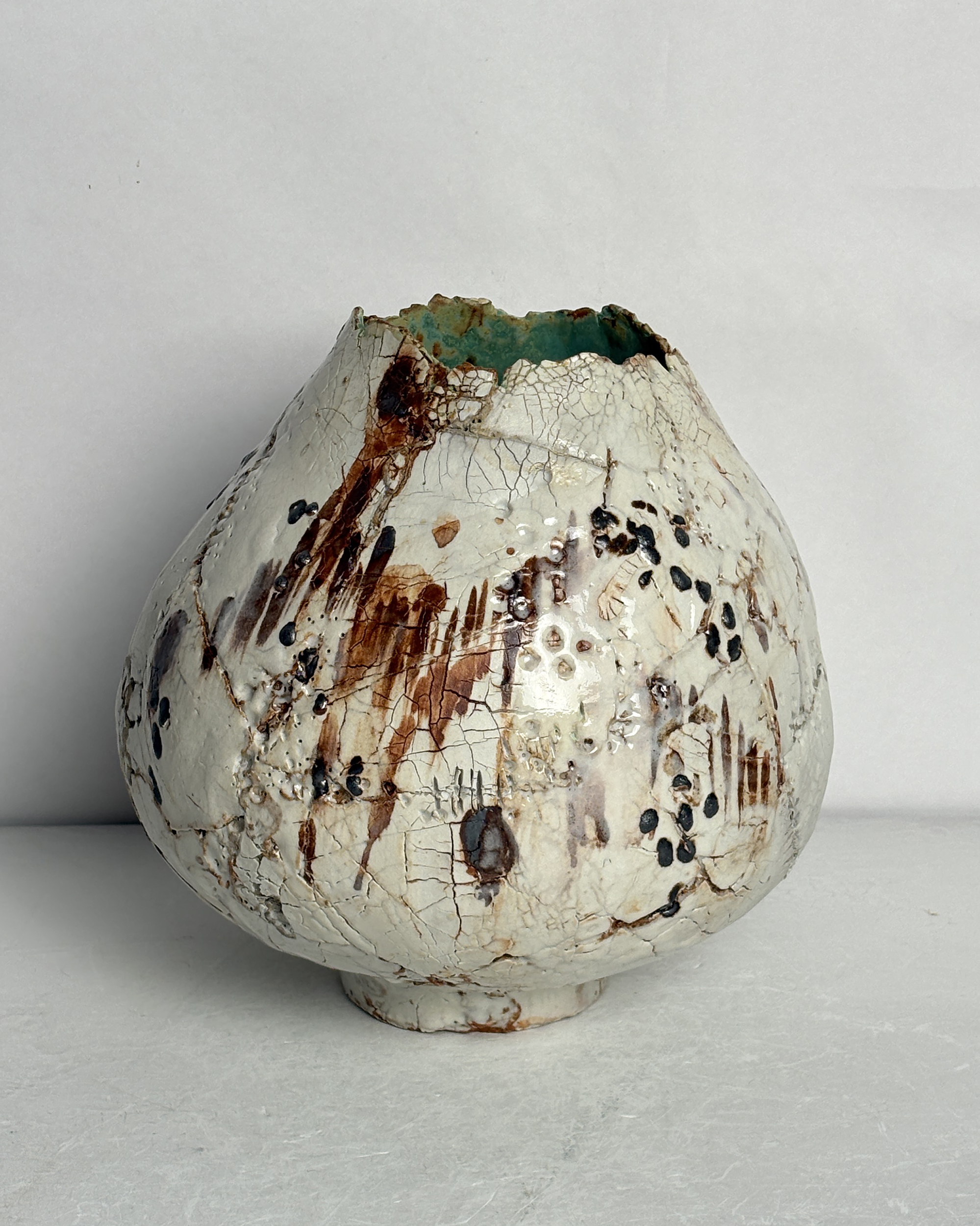 Vessel no. 69 - side 3 of ceramic vessel with white, brown and rust markings on a white cracked surface exterior with turquoise interior