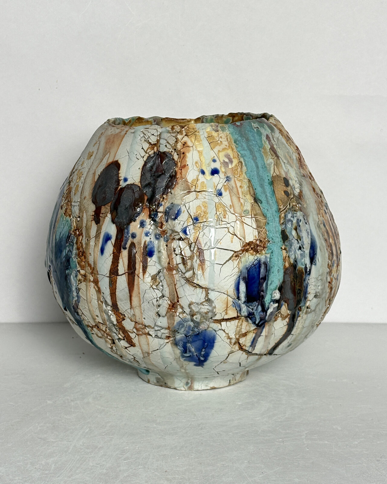 Vessel no. 70 - Side 2 of a round moon jar shaped ceramic vessel with 2 large china blue and turquoise dots and warm yellow interior