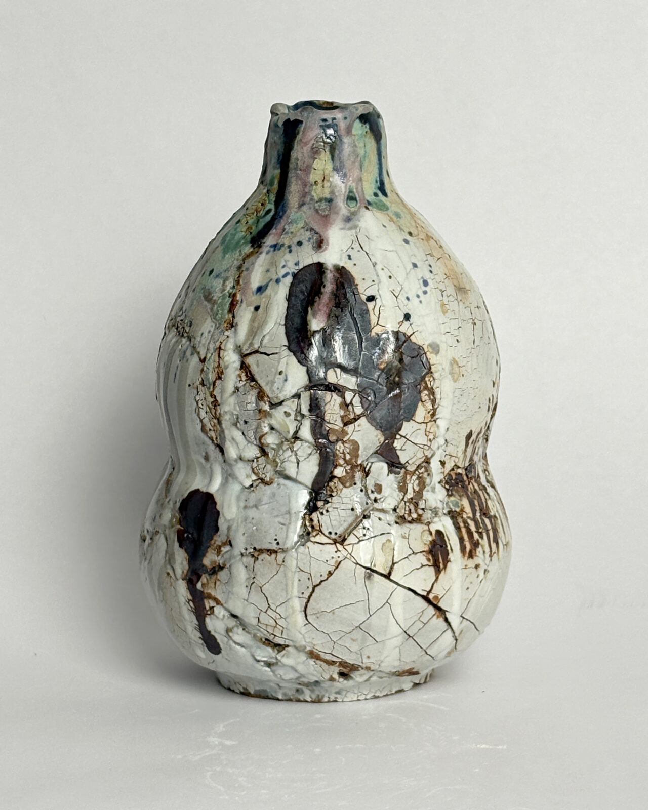 Front view of Vessel No. 61, a hand-built sculptural ceramic vessel with a rounded gourd-like form and fractured, layered glaze surface.
