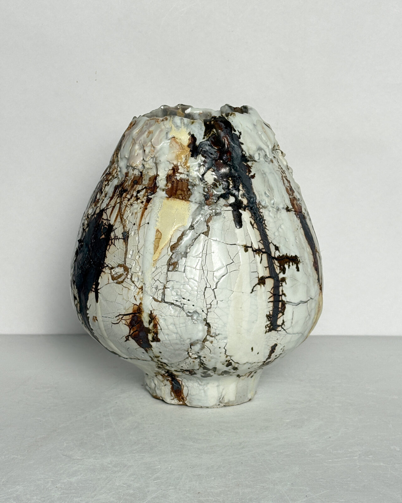 Vessel no. 68 - Side 2 of the tulip shaped ceramic vessel with a white cracked texture and rust brown making on a white ground and yellow accent