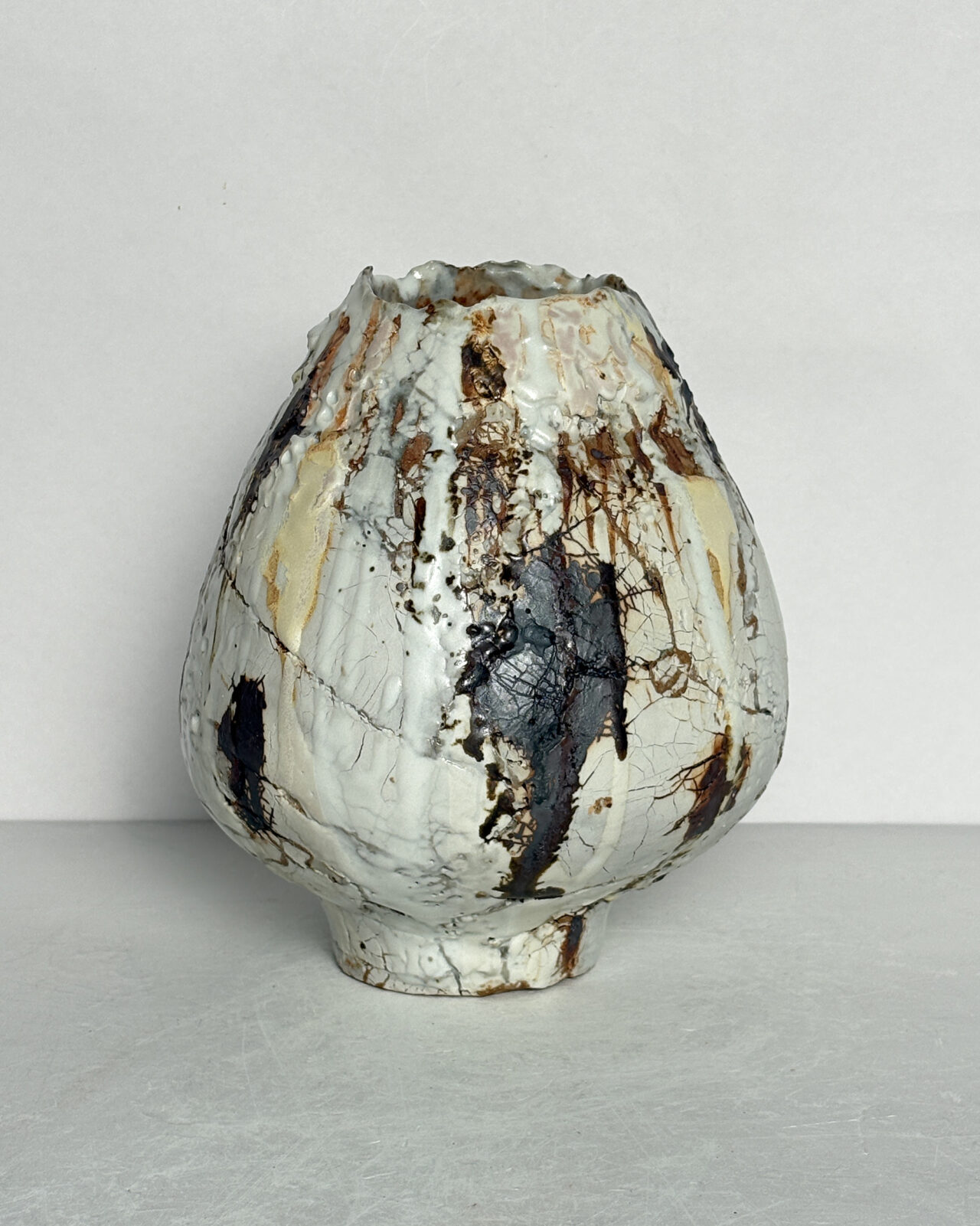 Vessel no. 68 - Side 3 of the tulip shaped ceramic vessel with a white cracked texture and rust brown making on a white ground and yellow accent